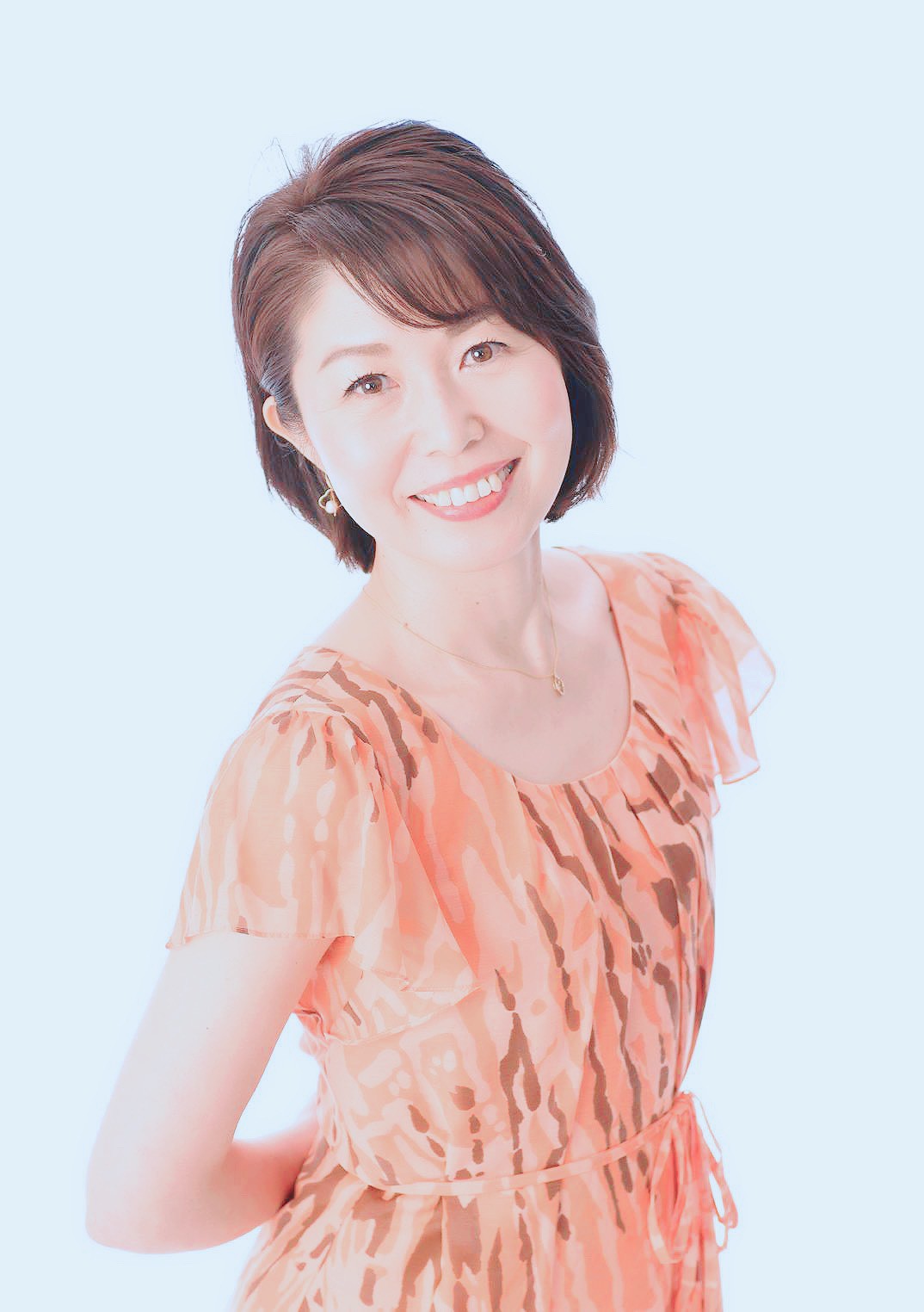 桜並木の中を前を向いて歩く女性